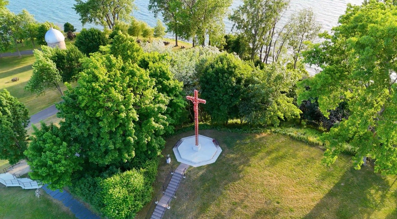 Aerial view of a manicured park space by the water.