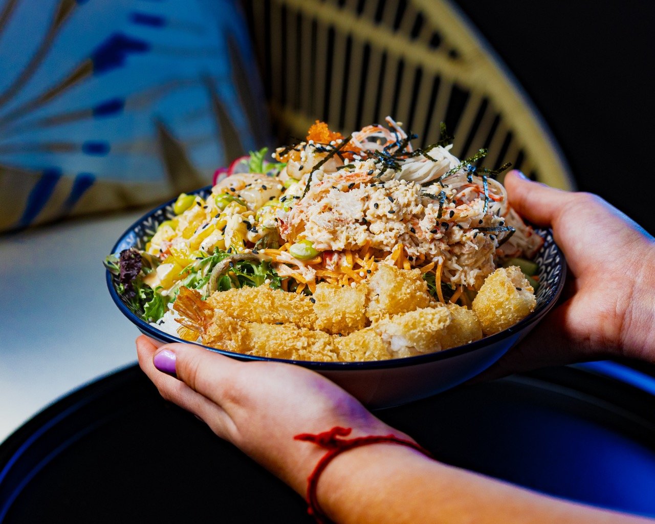 Close-up lifestyle shot of a person eating a delicious bite with chopsticks.